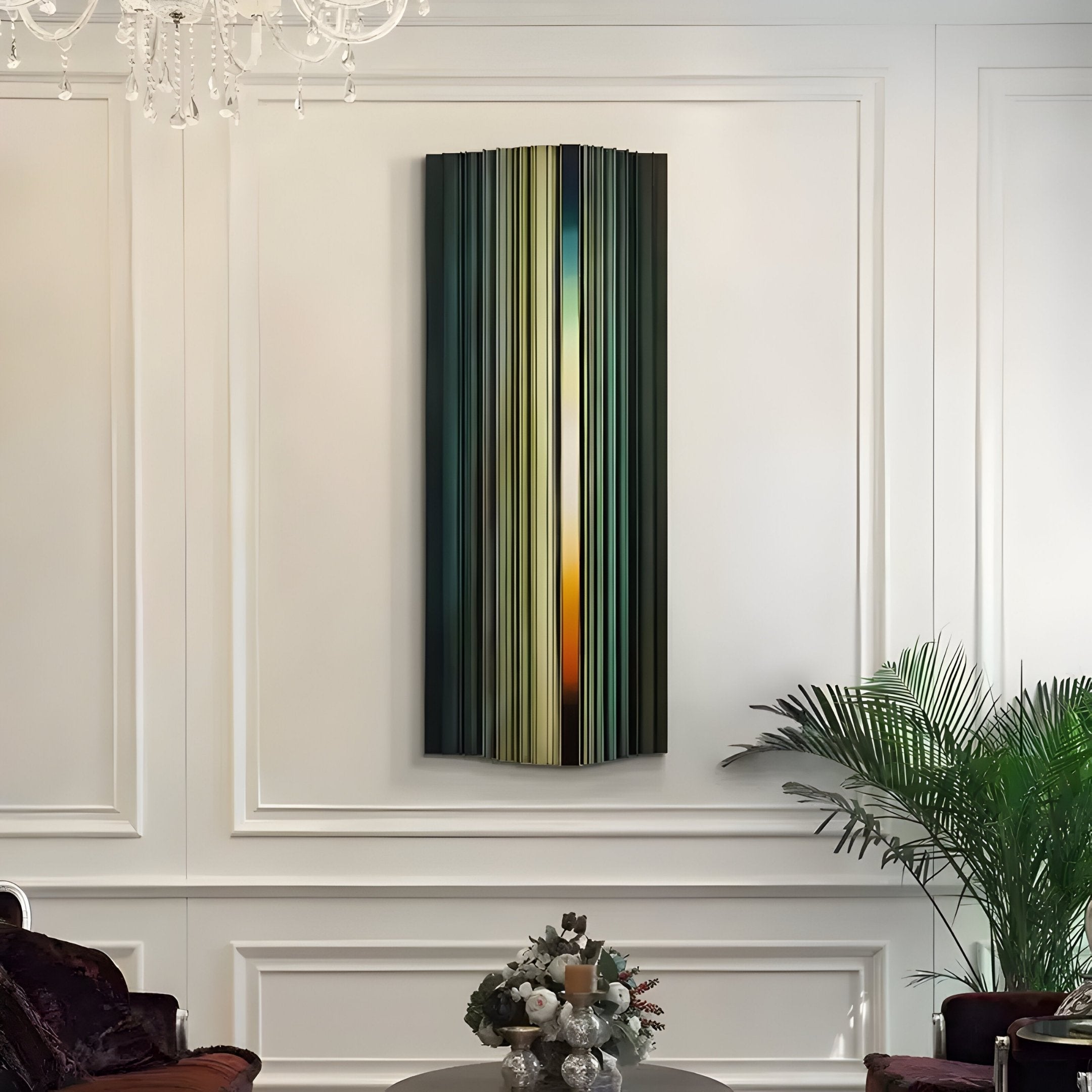 The Illumina Green Colourful Vertical Wooden Hand-Painted 3D Wall Art by Giant Sculptures adorns an elegant white-paneled wall. A chandelier is partially visible above, while a potted plant and decorative centerpiece sit below, enhancing the sophisticated interior setting.