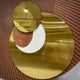 Orbitra Copper Reflective Circular 3D Wall Art by Giant Sculptures, three polished gold-toned mirrored discs in a staggered arrangement on a textured brown panel.