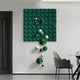 The Orbina Green 3D Wood Relief Wall Art by Giant Sculptures features stunning green and white geometric designs with metal spheres, enhancing a modern rooms decor. A textured green panel is wall-mounted, complemented by spheres below and glimpses of nearby furniture like a table and chair.