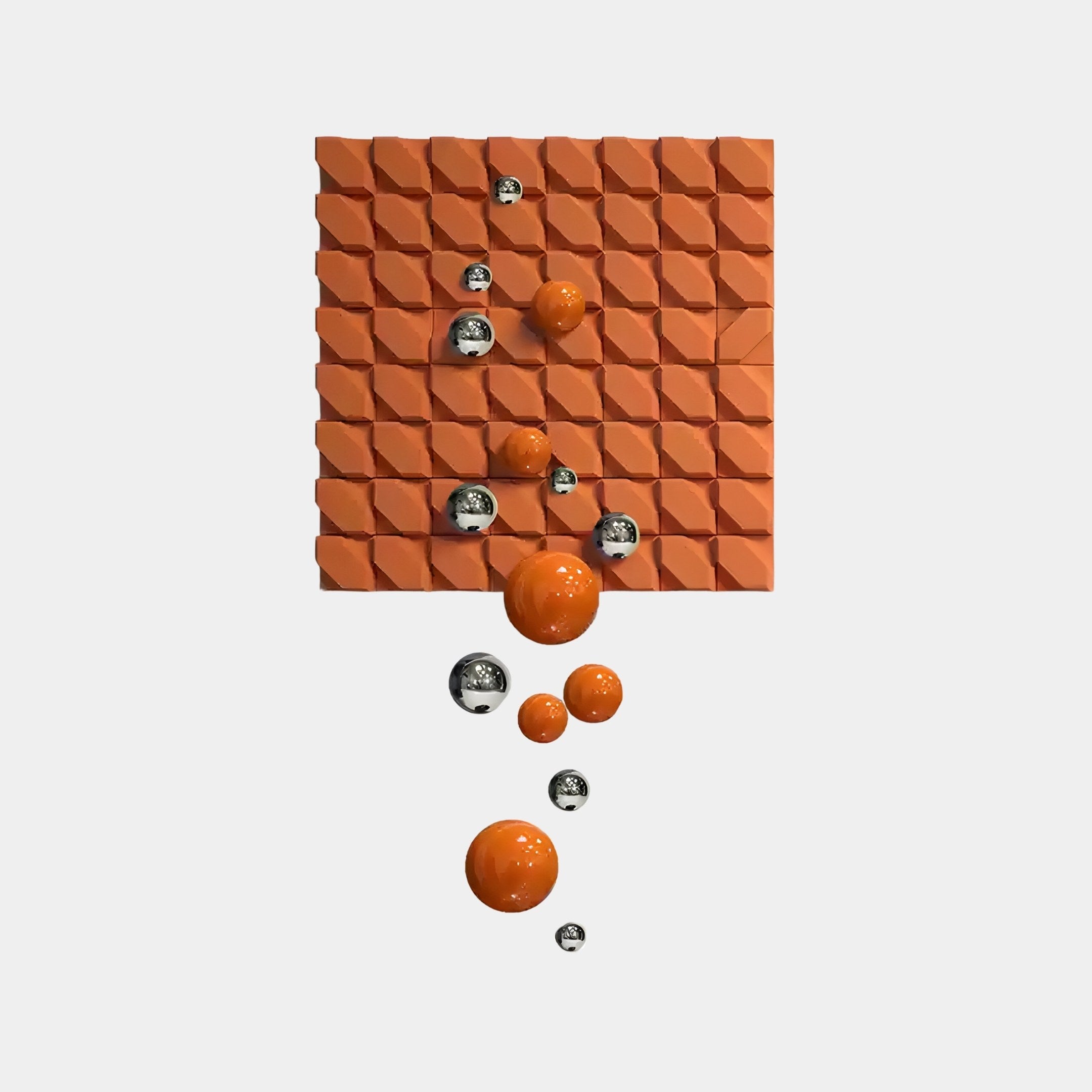 Introducing the Orbina Orange 3D Wood Relief Wall Art With Metal Ball by Giant Sculptures: an abstract piece featuring a textured square grid with raised diamond shapes, highlighted by silver and orange spheres that cascade across the grid, creating a dynamic geometric pattern.