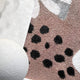 The Florere Neutral Bloom Hand-Painted Sandstone 3D Wall Art by Giant Sculptures showcases a textured surface with tan and gray hues, accented by black spots. Its white, rounded edge adds contrast, enhancing the speckled designs depth and dimension.
