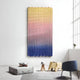 A modern room showcases the Spectrum Weave Vertical Sunset Hues Wood Relief 3D Wall Art by Giant Sculptures, with a gray cushion and plush toys, a small wooden table holding a book, and a blue chair near a tall window.
