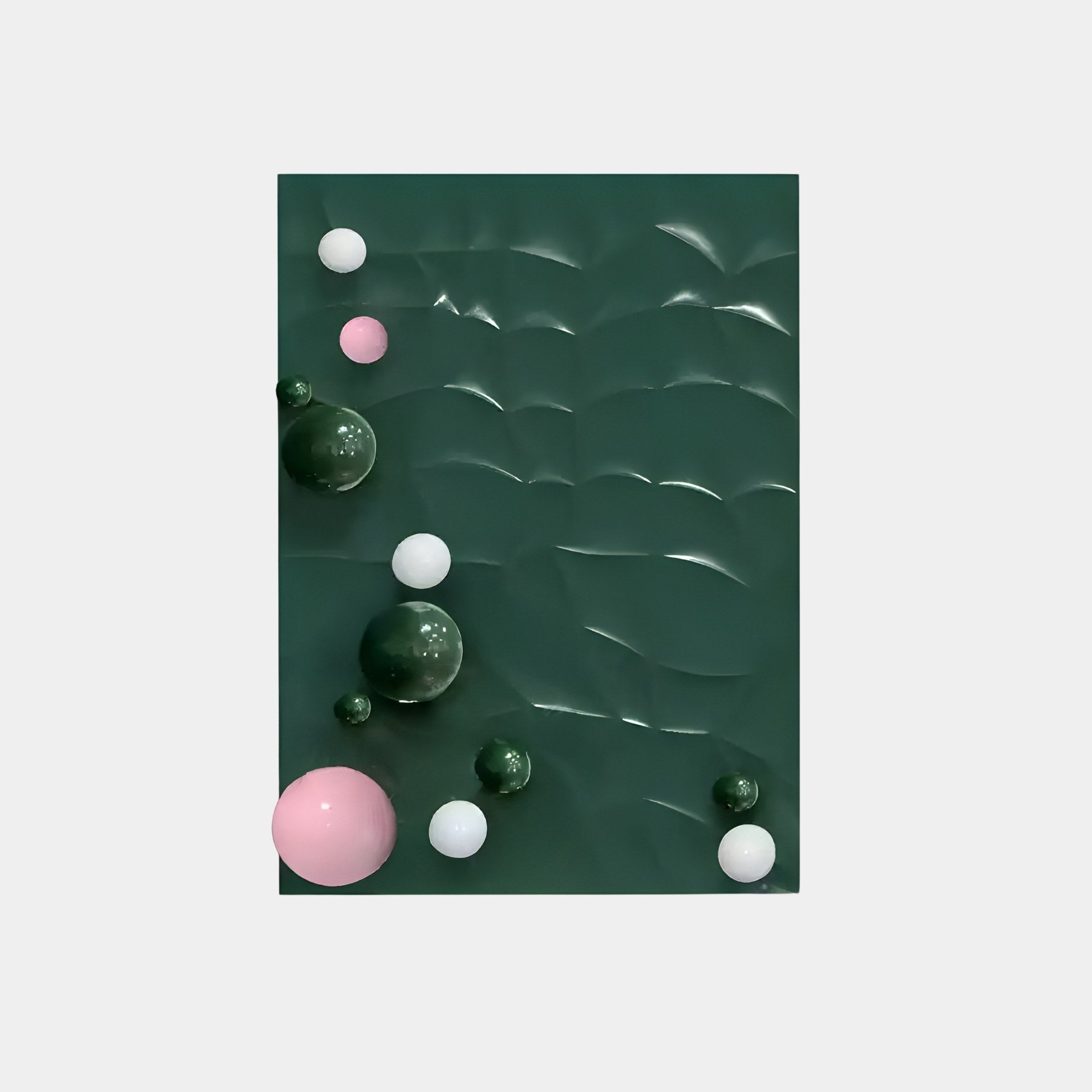 The Orbison Green 3D Wood Relief Wall Art With Metal Ball by Giant Sculptures features a wave-like texture with reflective curves and scattered metal spheres in pink, white, and darker green, creating a playful abstract design.