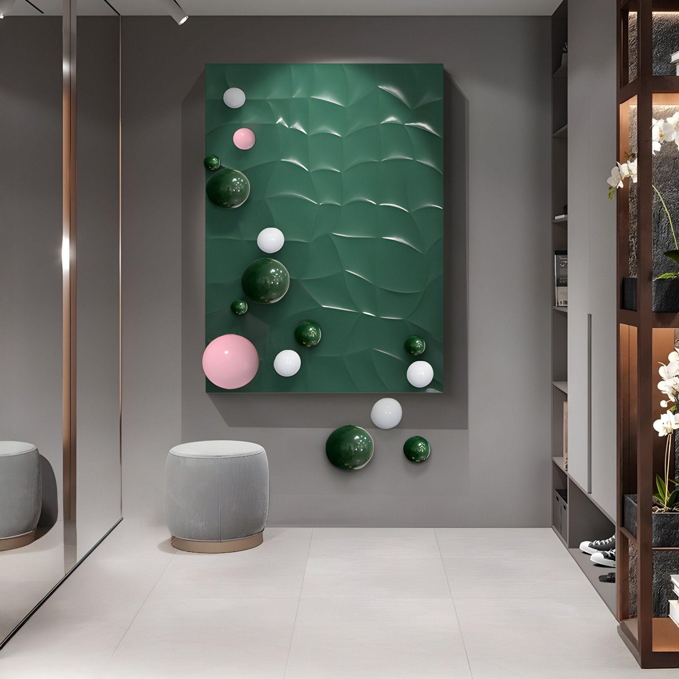 A modern room features a Giant Sculptures Orbison Green 3D Wood Relief Wall Art with textured spheres in pink, white, and dark green. A small gray stool complements shelves of plants and books, while a floating metal ball adds intrigue, all on light-colored flooring.