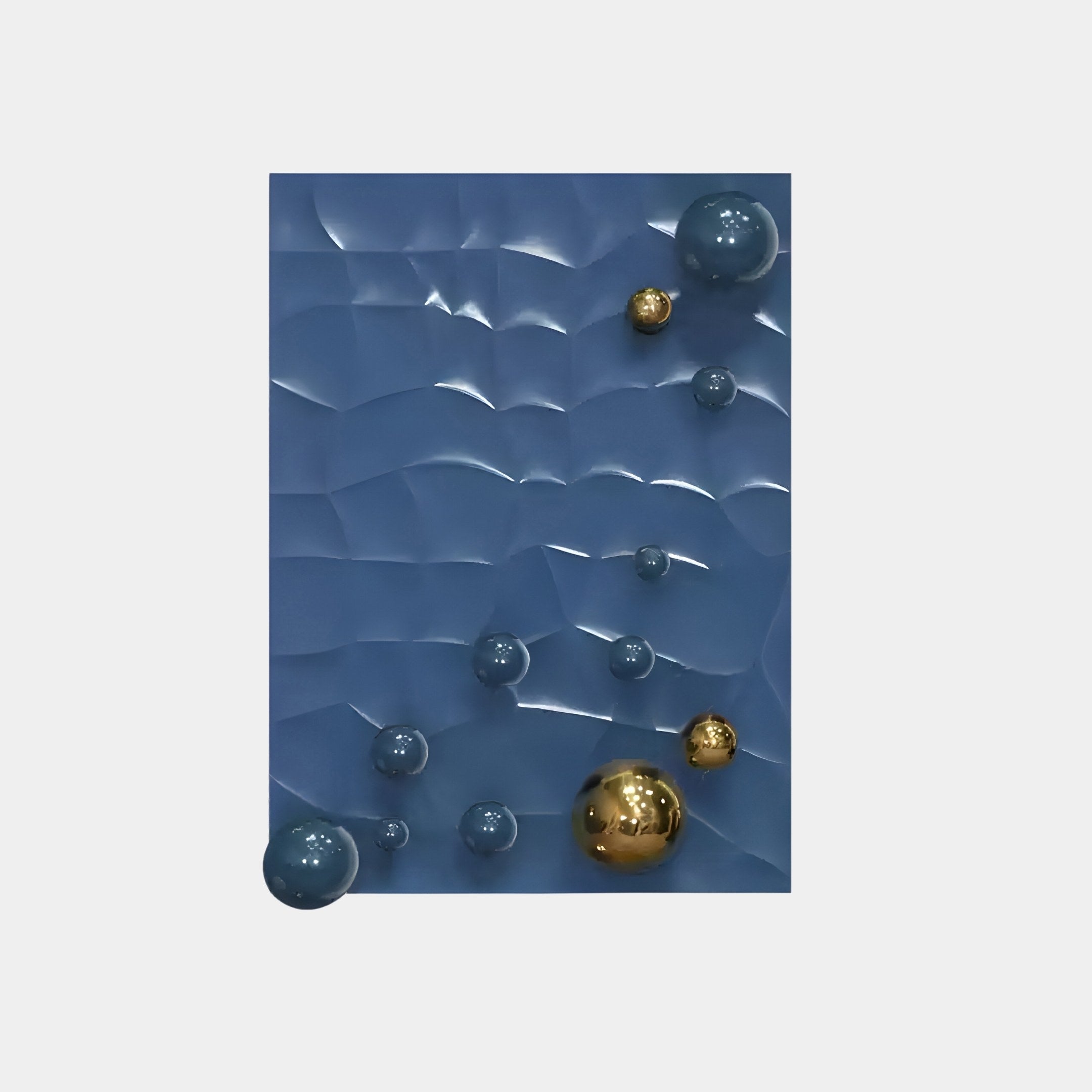 The Orbison Blue 3D Wood Relief Wall Art by Giant Sculptures features a textured wavy blue surface adorned with metal spheres and gold objects of various sizes on a light gray backdrop, perfect for modern interior décor.