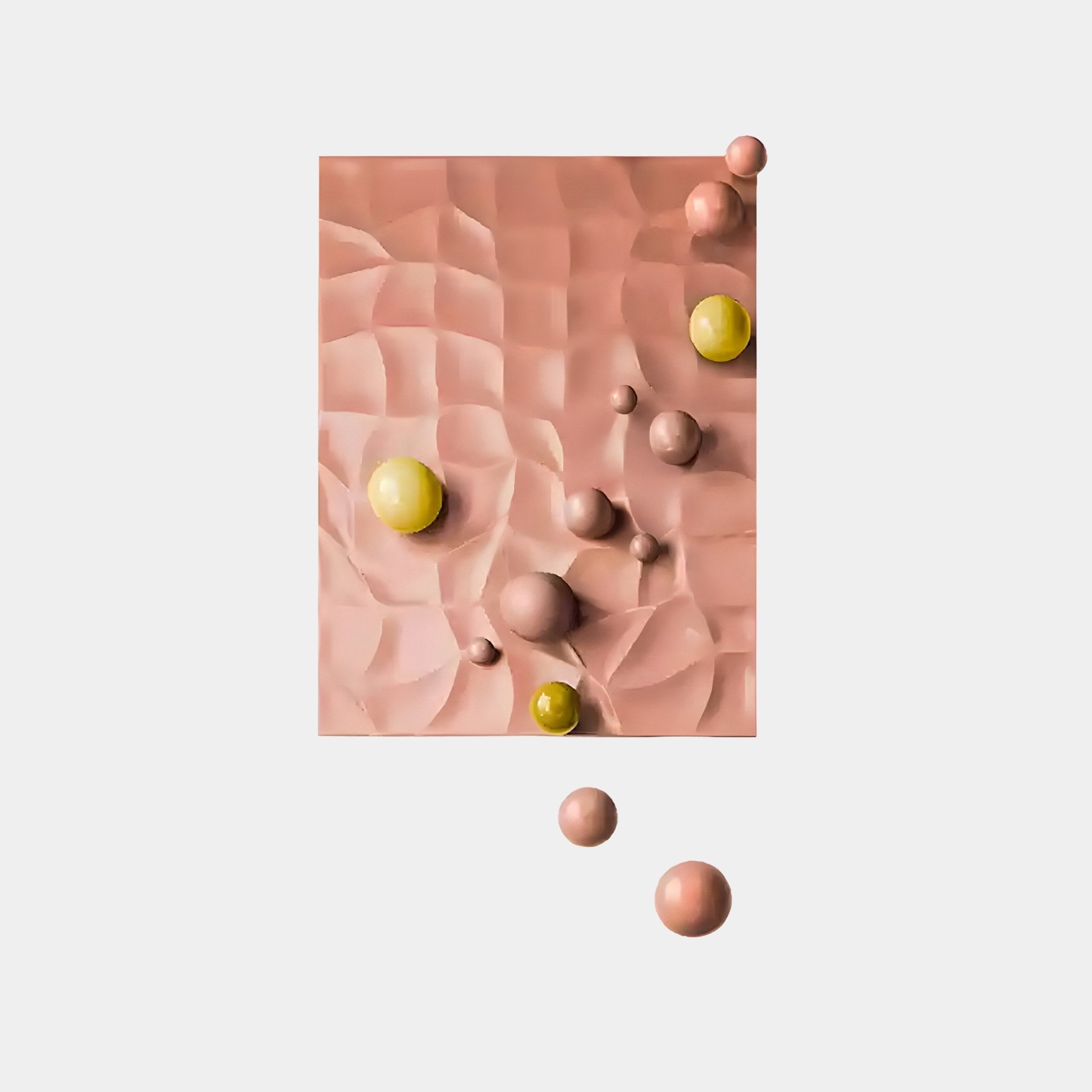 The Orbison Peach 3D Wood Relief Wall Art by Giant Sculptures displays a textured, wavy surface in soft pink with peach and light gold accents. Pink and yellow floating metal balls are scattered across a plain white background.