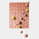 The Orbison Peach 3D Wood Relief Wall Art With Floating Metal Ball by Giant Sculptures features a textured pinkish-beige rectangle with wave patterns and smooth yellow and peach spheres, some floating against a white background.