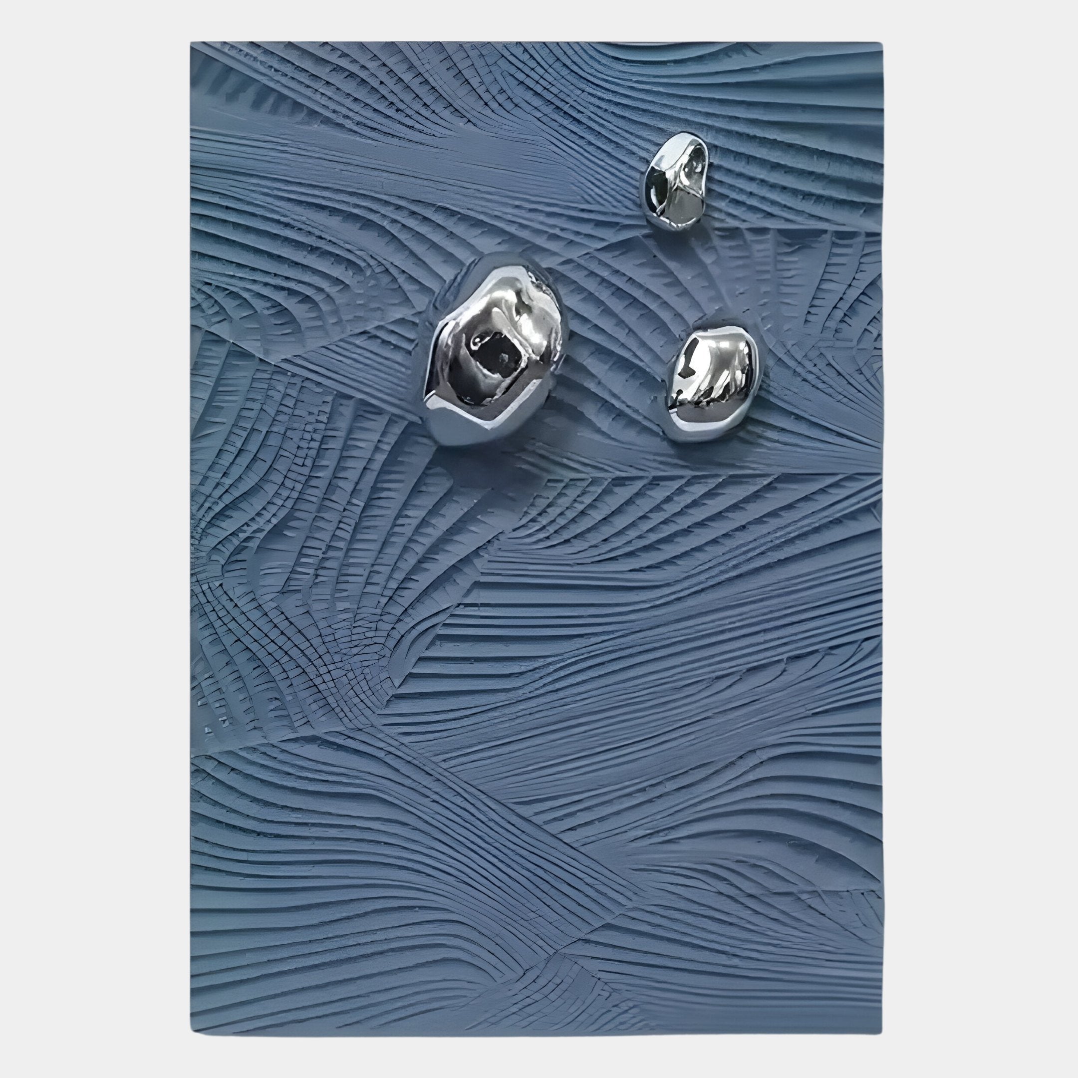 The Verdara Blue Wood Relief 3D Wall Art by Giant Sculptures features a textured blue surface with flowing lines and three reflective, irregular silver forms, creating a visually striking metallic accent piece.
