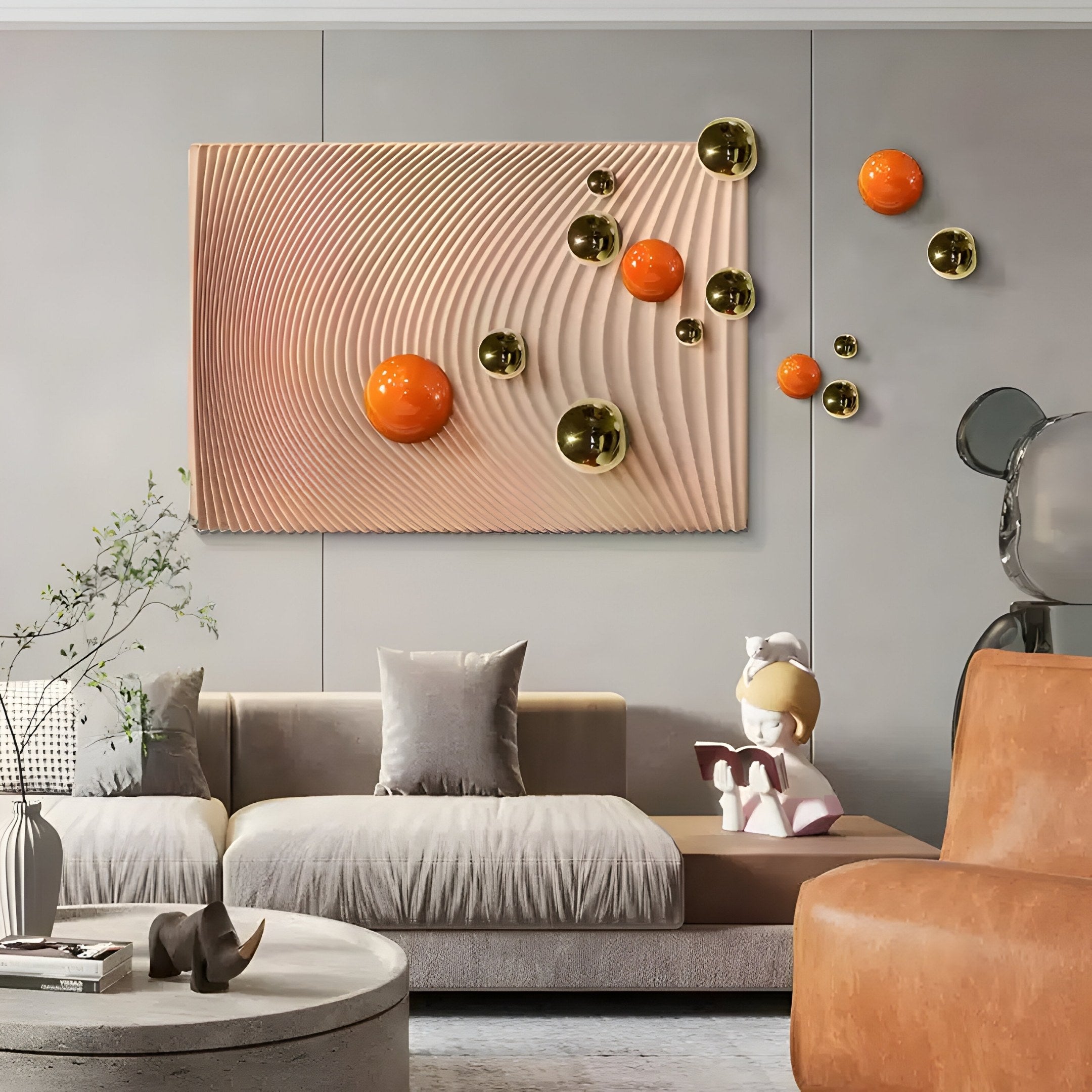 A contemporary living room features a beige couch and orange chair, adorned with Giant Sculptures Sphera Amber 3D Wood Relief Wall Art. A child reading sculpture sits on the couch, while a round coffee table and plant complete the aesthetic.