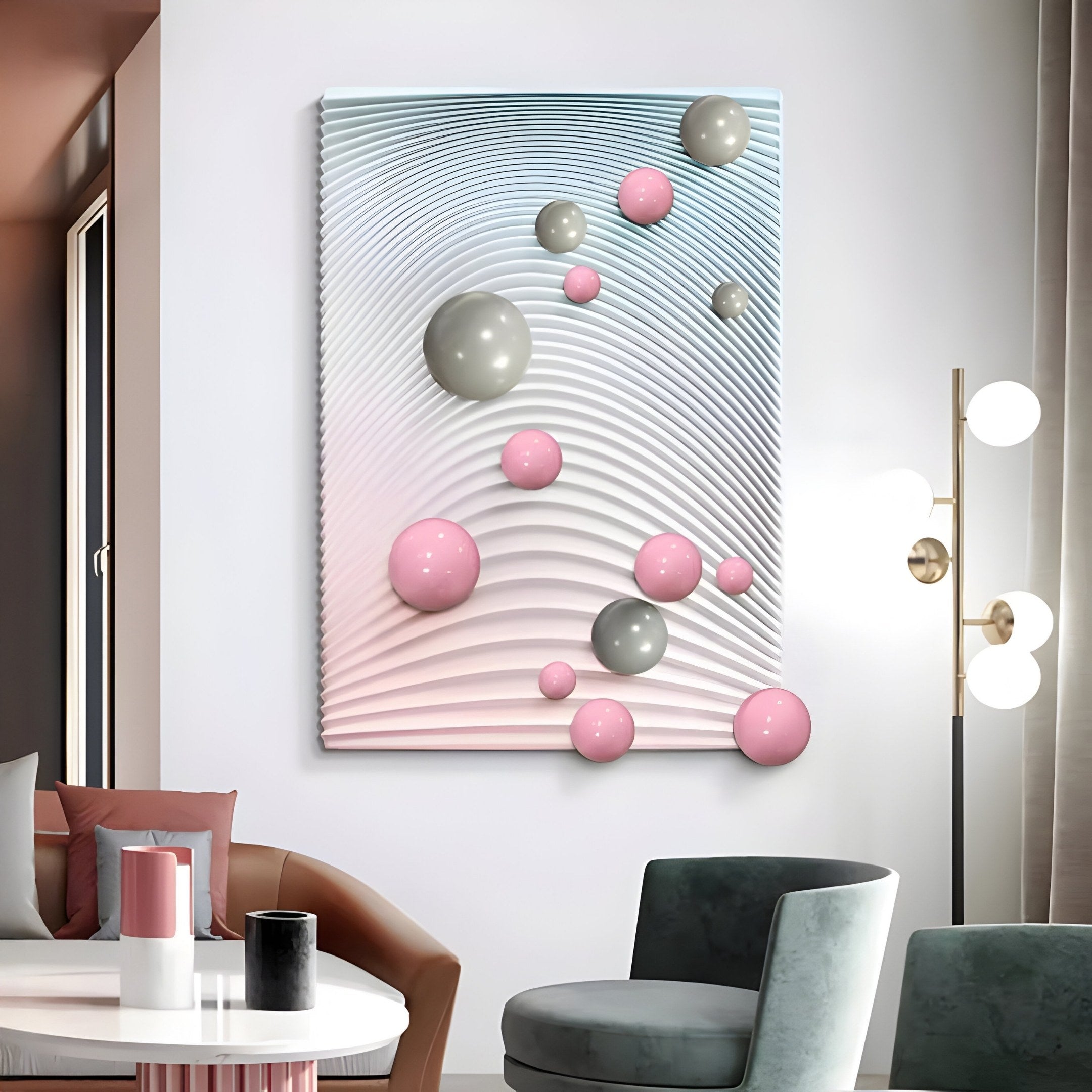 In a modern living room, the Sphera Gradient 3D Wood Relief Wall Art by Giant Sculptures, featuring grey and pink metal balls, stands out against a wavy backdrop. The space is complemented with a chic lamp, grey and pink chairs, and a white table with decorative accents.
