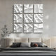 A modern bedroom showcases a beige upholstered bed with striped pillows and a cushion. Above the bed, Giant Sculptures Tessara I White 3D Wood Relief Wall Art forms a 3x3 grid of abstract patterns. Minimalist decor is enhanced by a slender plant on the left.