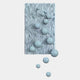 The Fluxion Soft Blue 3D Wood Relief Wall Art With Metal Ball by Giant Sculptures features a rectangular, textured blue panel with wavy grooves and glossy metal spheres of varying sizes emerging from the surface.
