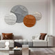 A modern living room features a white couch with brown and gray cushions, a wooden coffee table, and a small lamp. The wall displays Giant Sculptures Orbita 4-Set circular sand and rust 3D wood relief artworks, enhancing the ambiance.