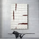 The Striata White & Burgundy Wood Carving 3D Wall Art by Giant Sculptures, featuring wave-like patterns in white and dark red, is mounted on a light gray paneled wall. Below it, an abstract black sculpture adds to the striking visual harmony.