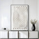 Giant Sculptures Elorium White Strata Hand-Painted Wood Relief 3D Wall Art, with geometric designs, is mounted above a white cabinet. A black vase holding small white flowers sits next to a decorative black and white item, enhancing the rooms depth and style.