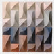 The Elysia Geometric Warm Gradient Wood Relief 3D Wall Art by Giant Sculptures features 20 square panels with curved and straight shapes in beige, gray, blue, and brown—ideal 3D wall art for modern interiors.