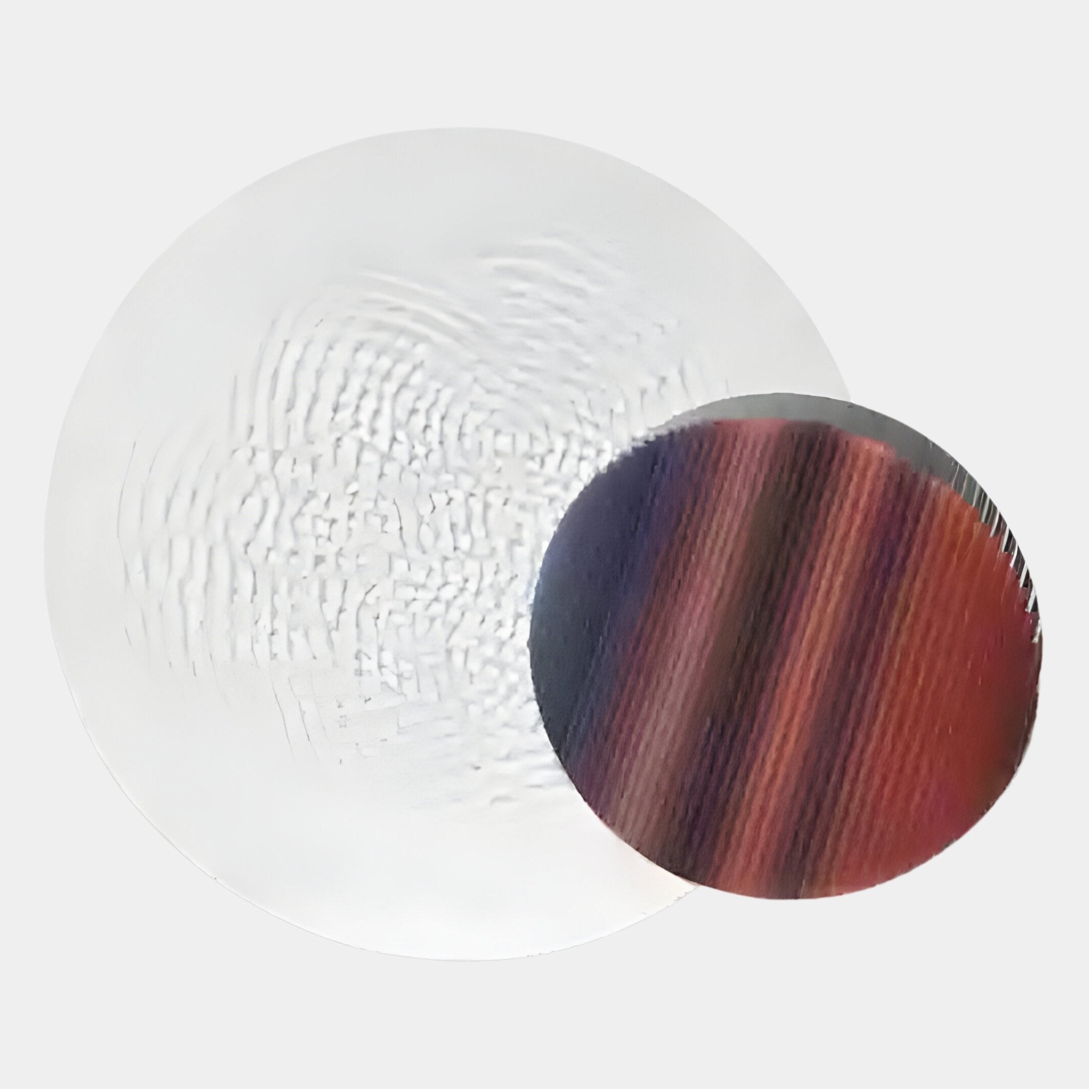 Two silicon wafers rest on a light background: the larger is silver, and the smaller features vivid red, purple, and black stripes reminiscent of Giant Sculptures Lucentis White & Earthy Gradient Wood Relief 3D Wall Art.