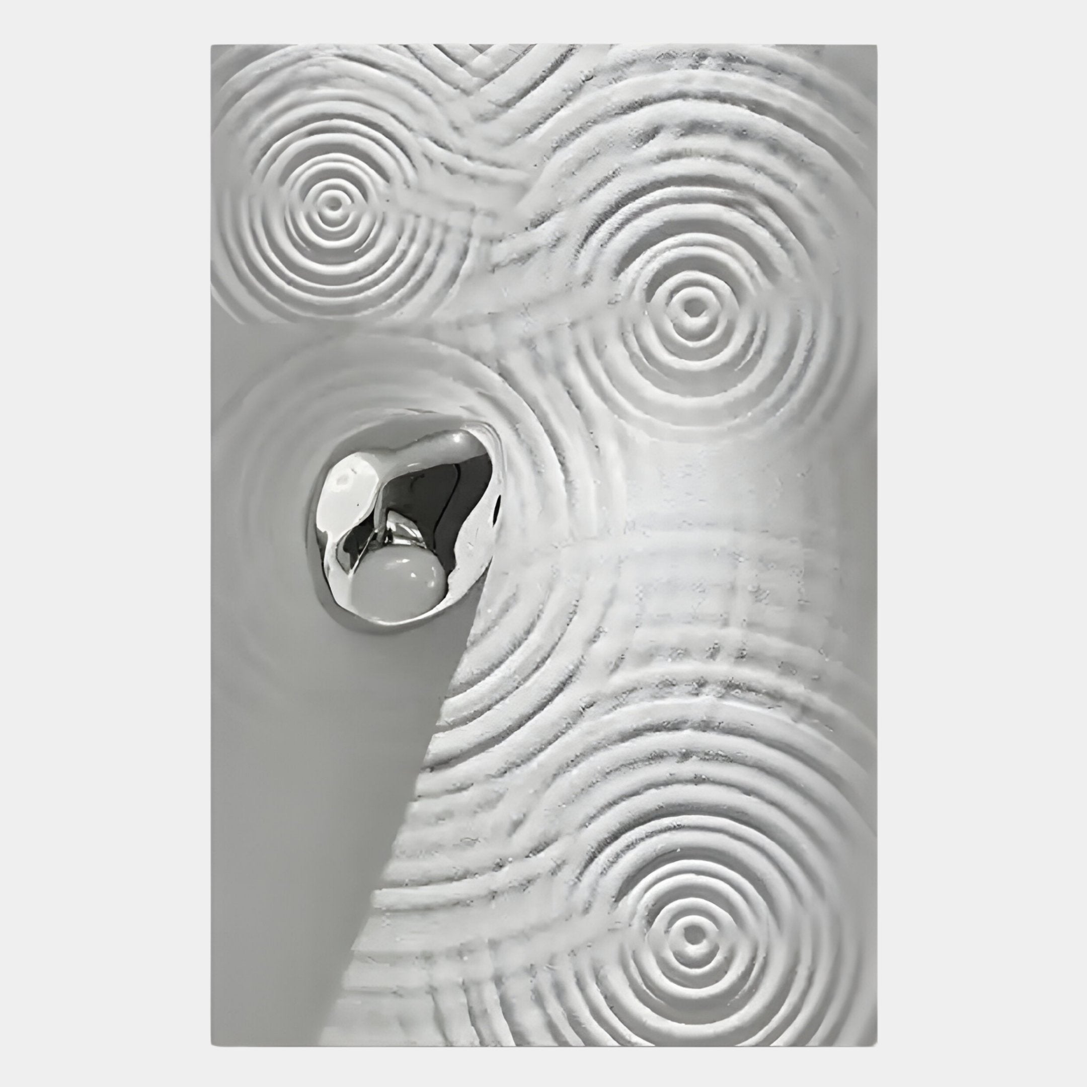 A metallic, irregular object rests on a textured surface with concentric ripples, reminiscent of Giant Sculptures Ondella Silver Ripple III Sandstone Wood Relief 3D Wall Art, in gleaming silver and white tones for a modern, abstract look.