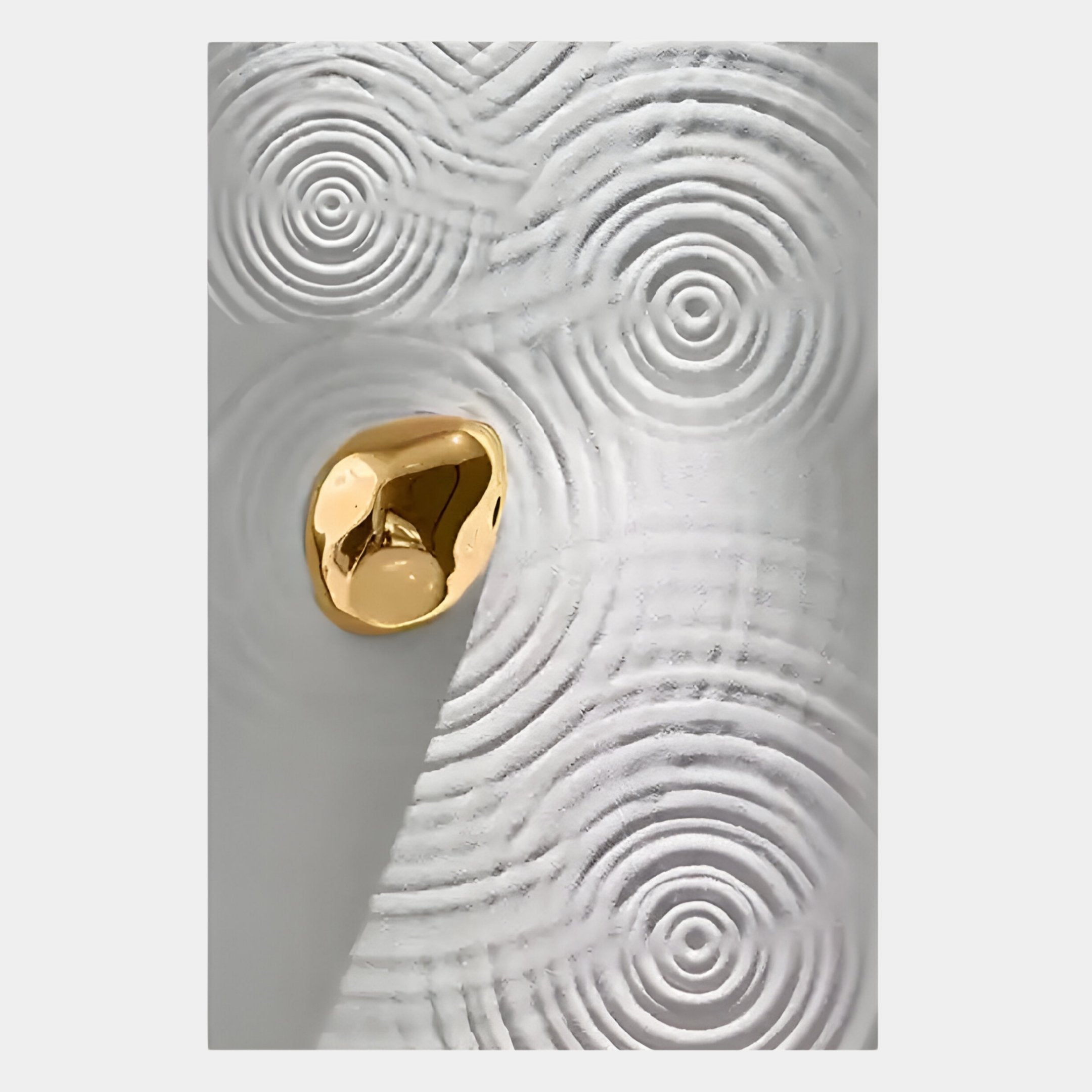 The Ondella Gold Ripple III Sandstone Wood Relief 3D Wall Art by Giant Sculptures features concentric white circular patterns and an off-center gold accent, creating a contemporary 3D effect with dynamic light and shadow.