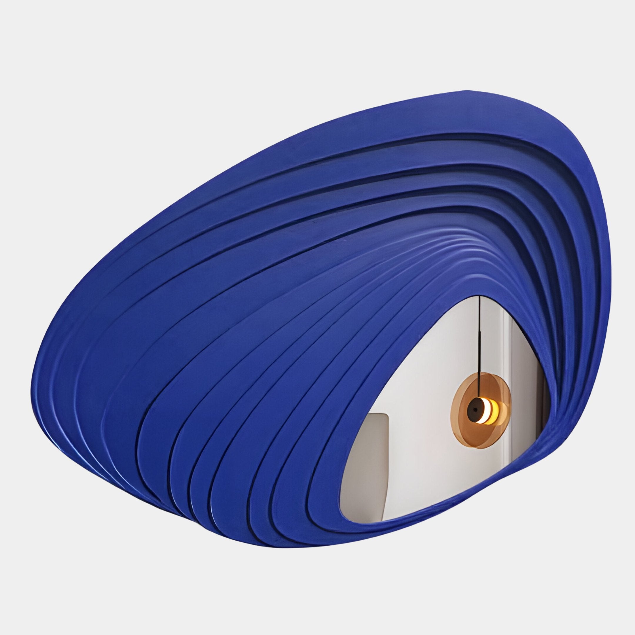 The Reflecta Blue Wood Carving Mirror 3D Wall Art by Giant Sculptures features layered, curved blue panels and an opening revealing a minimalist interior with a round gold pendant light, creating a striking abstract design.