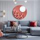 A modern living room features a gray sectional sofa accented by red and pink cushions. The gray wall is adorned with the Verve Dusty Rose Wood Relief 3D Wall Art by Giant Sculptures. Two round coffee tables, topped with decorative vases, and hanging globe lights add a contemporary touch.