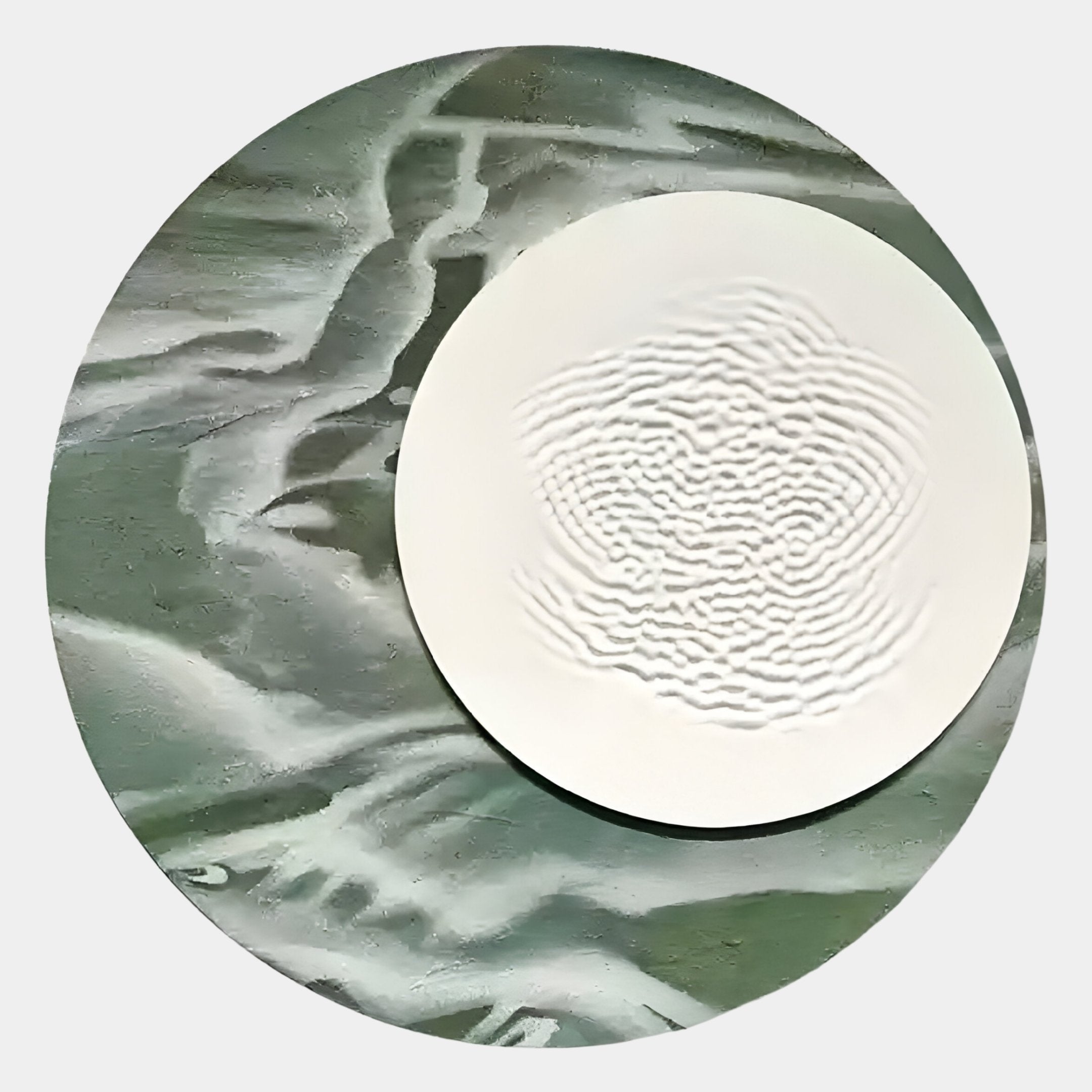 The Reveria Sage Green Abstract Wood Carving 3D Wall Art by Giant Sculptures features a textured white circular disk atop a sage green surface, set against a light gray background—ideal for modern interiors.
