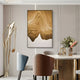 A modern dining room with pastel chairs, a gold dining table, flowers in a vase, a gold abstract sculpture, and striking Celoria Golden Dune Wood Carving 3D Wall Art by Giant Sculptures displayed on the wall.