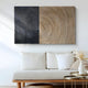 A modern living room with a white couch features the Artura Beige & Black Hand-Painted 3D Relief Wall Art by Giant Sculptures, its bold concentric circles complemented by a minimalist table and vase of dried flowers.