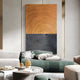 A modern living room includes a green sectional sofa with pillows, a white vase with flowers on a small table, and Giant Sculptures’ Artura Honey & Black Hand-Painted 3D Relief Wall Art, featuring bold abstract concentric circles for minimalist style.