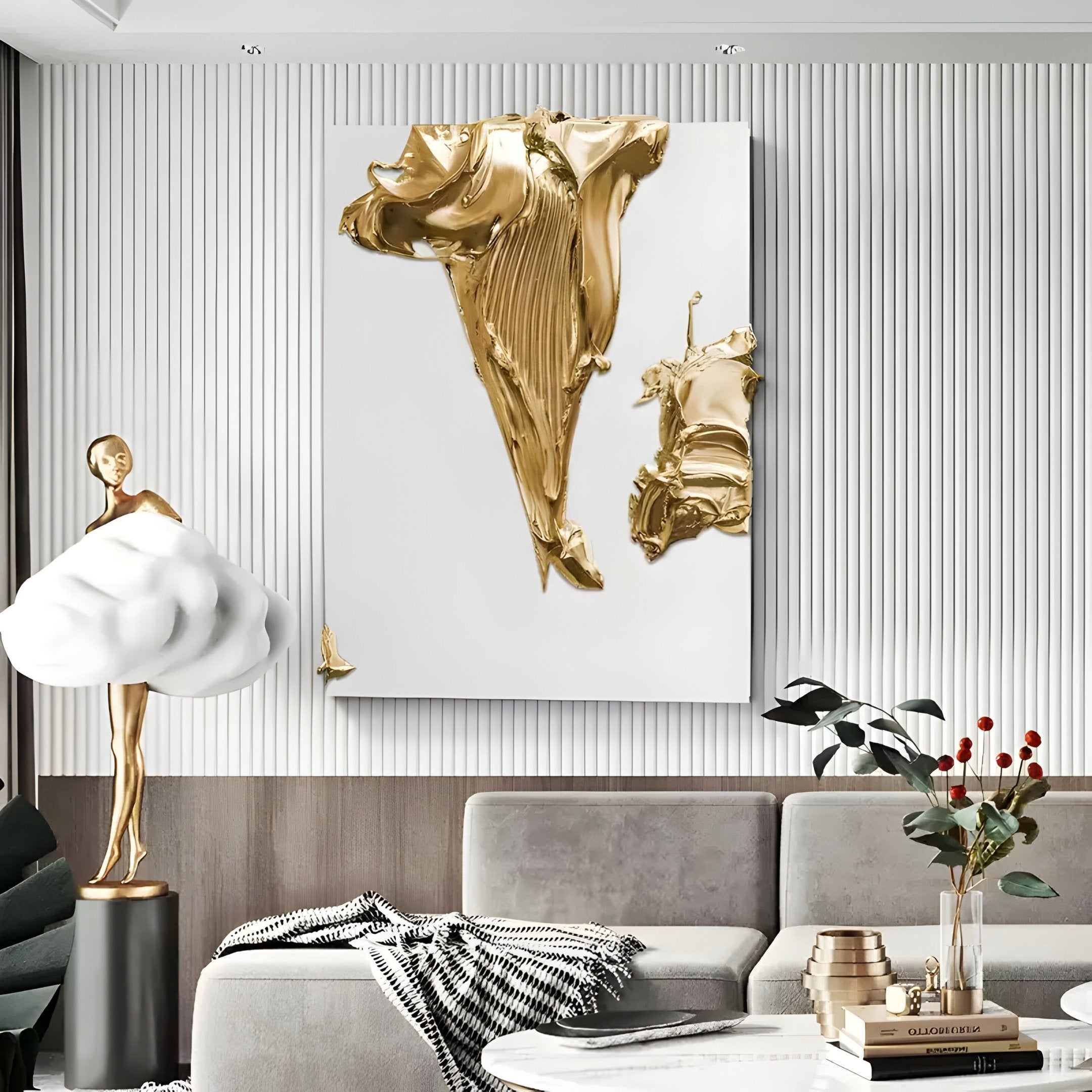 A modern living room features a gray sofa, Giant Sculptures Opulina White & Gold II Wood Relief 3D Wall Art above, a sculptural figure with a cloud-like skirt, plants, and a coffee table with stacked decor and red berries in a vase.