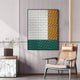A modern living space showcases Giant Sculptures Trelume White, Green & Gold Wavy Wood Relief 3D Wall Art on a striped wall, paired with a cane armchair and a marble side table topped with a vase of greenery.