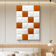 The Vellura White & Orange Textured Wood Relief 3D Wall Art by Giant Sculptures hangs above a modern bed with neutral bedding and a built-in headboard, beside a white and gold wall lamp.