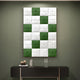 The Vellura White & Green Textured Wood Relief 3D Wall Art by Giant Sculptures hangs above a sleek black console table adorned with books, a small sculpture, and a glass of water.