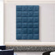 The Vellura Blue Textured Wood Relief 3D Wall Art by Giant Sculptures, featuring wavy panels in a 6-by-5 arrangement, brings sculptural elegance to modern, minimalist rooms with light walls and a terrazzo bench below.