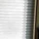 Close-up of Giant Sculptures Artevia Gold & White Geometric Wood Relief 3D Wall Art, with sunlight casting patterns of light and shadow across the textured surface, highlighting its sculptural design from the left side.