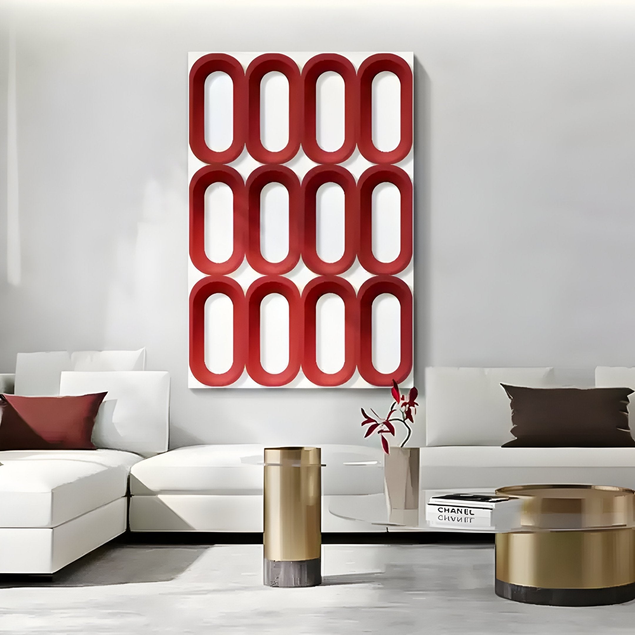 A modern living room features white sofas, gold cylindrical coffee tables, and the Revela White & Red Geometric Wood Relief 3D Wall Art by Giant Sculptures. Decorative books and a vase with red leaves enhance the bold, sculptural vibe.