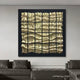A modern living room with gray couches and a glass coffee table, showcasing the Aurion Black & Gold Glossy Wood Carving 3D Wall Art by Giant Sculptures—metallic squares with wavy texture, ideal for contemporary spaces.