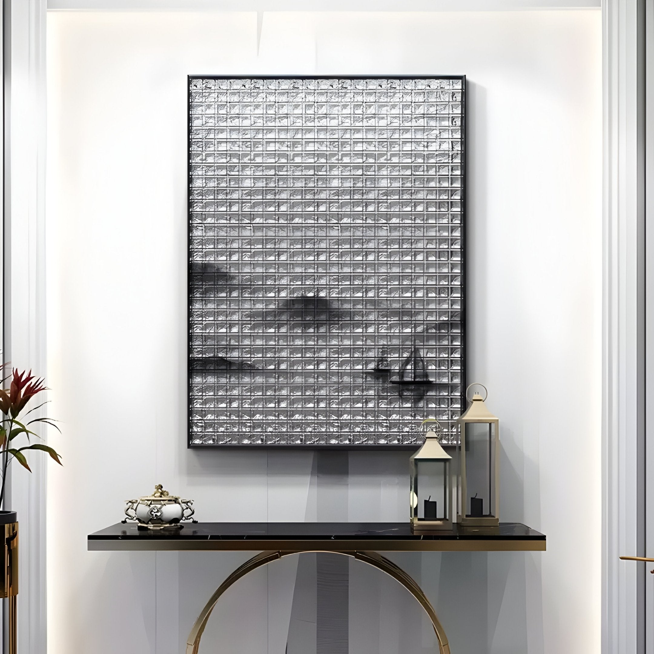 A modern interior features a decorative black console table with a lantern, potted plant, and small sculpture. Above it hangs the Synova Silver II Hand-Painted Wood Relief 3D Wall Art by Giant Sculptures, with textured abstract patterns resembling a zen-inspired landscape on the white wall.