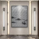 The Synova Silver II Hand-Painted Wood Relief 3D Wall Art by Giant Sculptures, a large textured monochrome piece, hangs on a softly lit neutral wall, flanked by two modern vertical light fixtures above polished gray marble tiles.