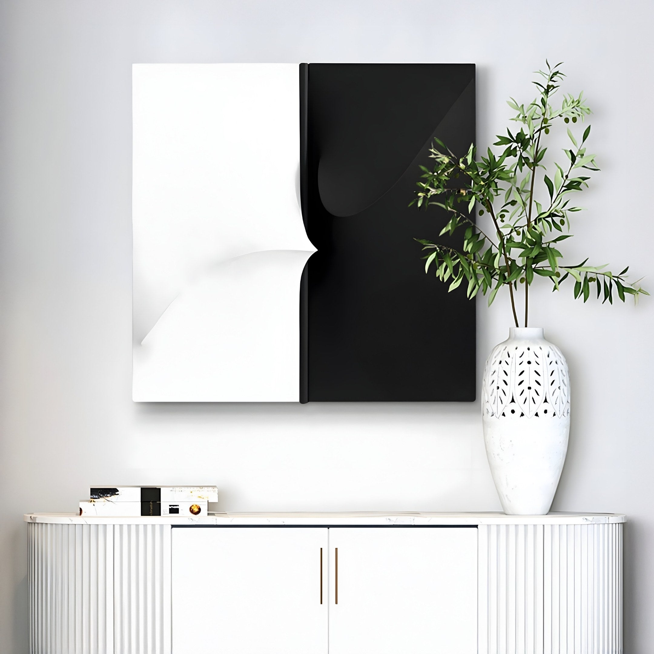 A minimalist interior showcases a Delinea Dual Contrast Black & White Fabric 3D Wood Relief Wall Art by Giant Sculptures above a sleek white cabinet. A tall vase with green branches adds natures touch, while the setting exudes contemporary elegance with its captivating intricate design.