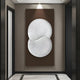 A modern hallway features the Artivio Dark Brown & White Wood Relief 3D Wall Art by Giant Sculptures, highlighting minimalist design. The neutral walls and light marble-patterned tiles elegantly contrast with doors flanking each side.