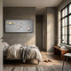 A cozy modern bedroom in neutral tones features a neatly made bed, wooden bench, slippers, and the Astravera Saturn Loop Gold Ring Planet Astronaut 3D Wall Art by Giant Sculptures—ideal for fans of planetary-themed decor.