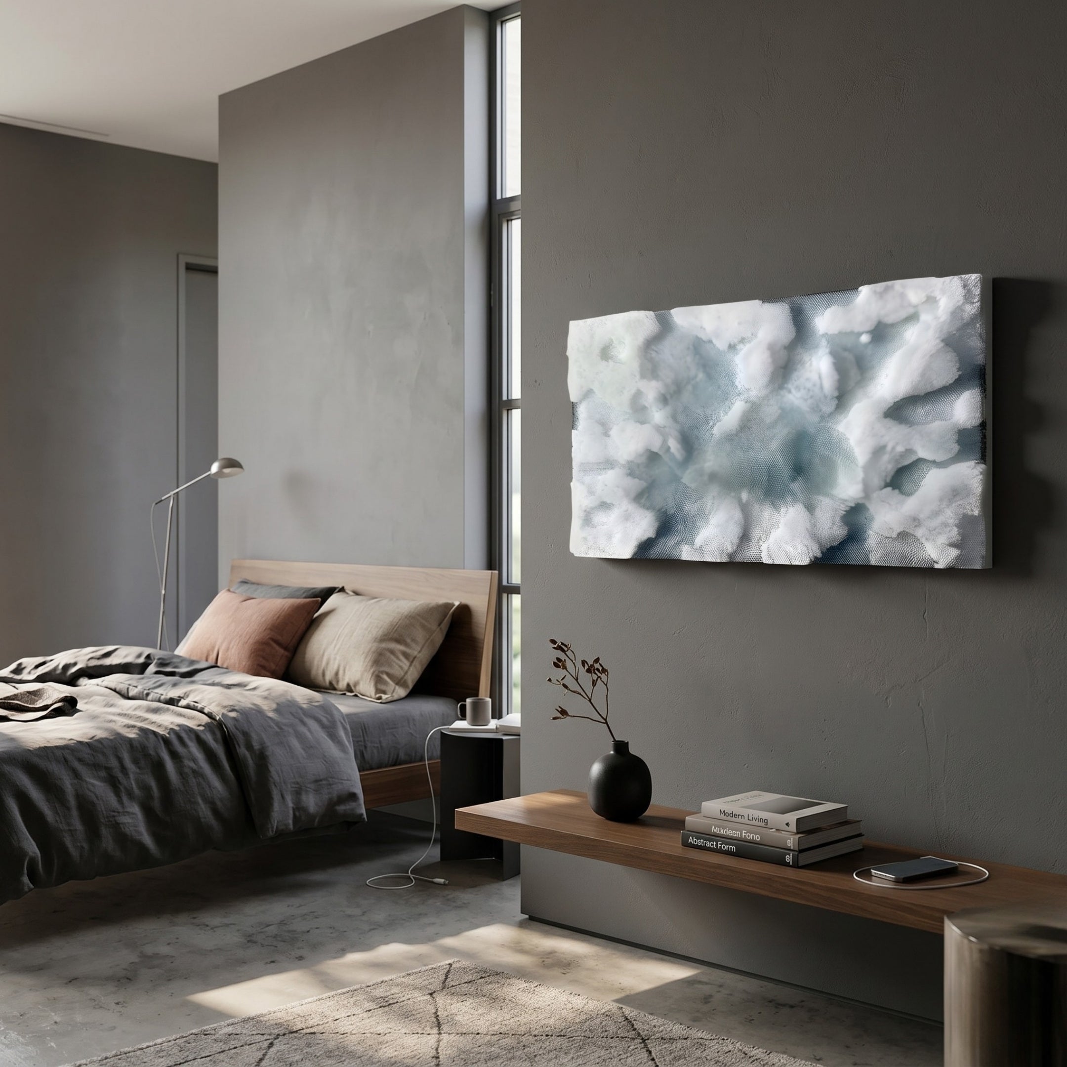 A modern, minimalist bedroom features a gray bed, brown and beige pillows, a wooden bench with books and a vase, and Giant Sculptures’ Nivara Ice Blue Ripple Straw 3D Wall Art. Sunlight streams in through tall windows, warming the cozy interior.