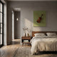 A cozy, sunlit bedroom features a wooden bed with beige bedding, a nightstand with books and a vase, and Giant Sculptures’ Archetto Olive Violin Acrylic Framed 3D Wall Art above the bed. Tall windows brighten the wooden floor.