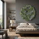 A modern bedroom features a large bed with neutral bedding, wooden furniture, and the Rivora Green Ribbon Leather Circular 3D Wall Art by Giant Sculptures above the bed; natural light from the window enhances the contemporary style.