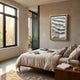 A modern bedroom with large windows, a neatly made bed, wooden nightstand, books, and gold lamp features the Linscario Chrome Weave Ripple Texture 3D Wall Art by Giant Sculptures above the bed as sunlight fills this luxury space.