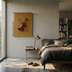 A cozy bedroom with a neatly made bed, a nightstand with books and a lamp, slippers on a patterned rug, and the Archetto Beige Violin Acrylic Framed 3D Wall Art by Giant Sculptures displayed above the nightstand.