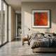 A modern bedroom with gray bedding, a bedside table with books and a lamp, large windows, and the Stratonis Ember Linear Textured Framed Wall Art by Giant Sculptures boldly displayed above the bed.