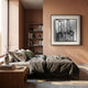 A modern bedroom with pinkish-brown walls, a low bed in gray and green bedding, a wooden nightstand and bookshelf with books, and the Stratonis Monochrome Abstract Textured Framed Wall Art by Giant Sculptures above the bed.