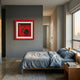 A modern bedroom with gray walls, a wooden bed with blue-gray bedding, a bedside table with a book, large windows, and vintage-inspired decor including the Cavendro Single Cigar & Checked Case Framed Wall Art by Giant Sculptures.